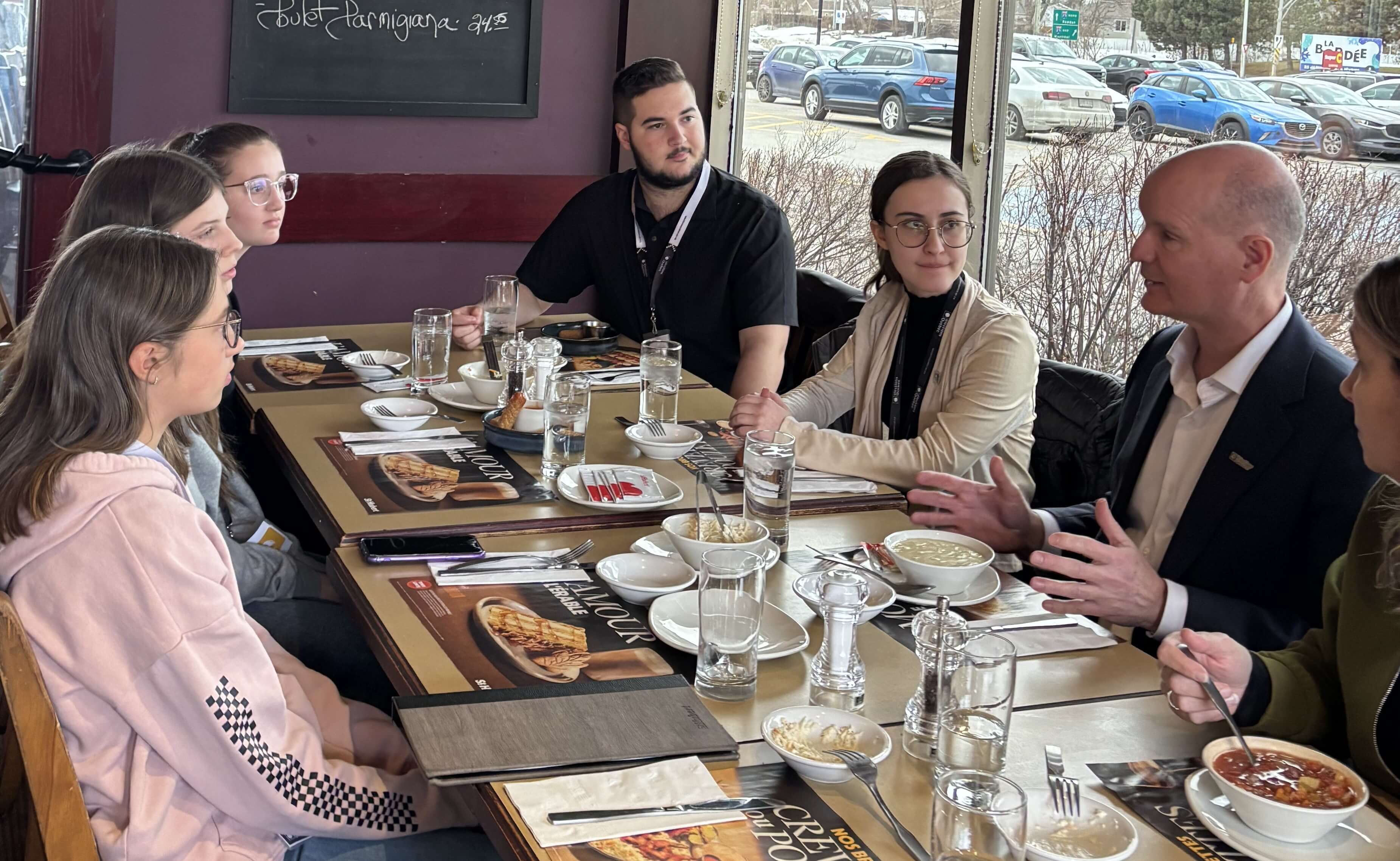 Cinq jeunes qui cassent la croûte avec le directeur général des élections.