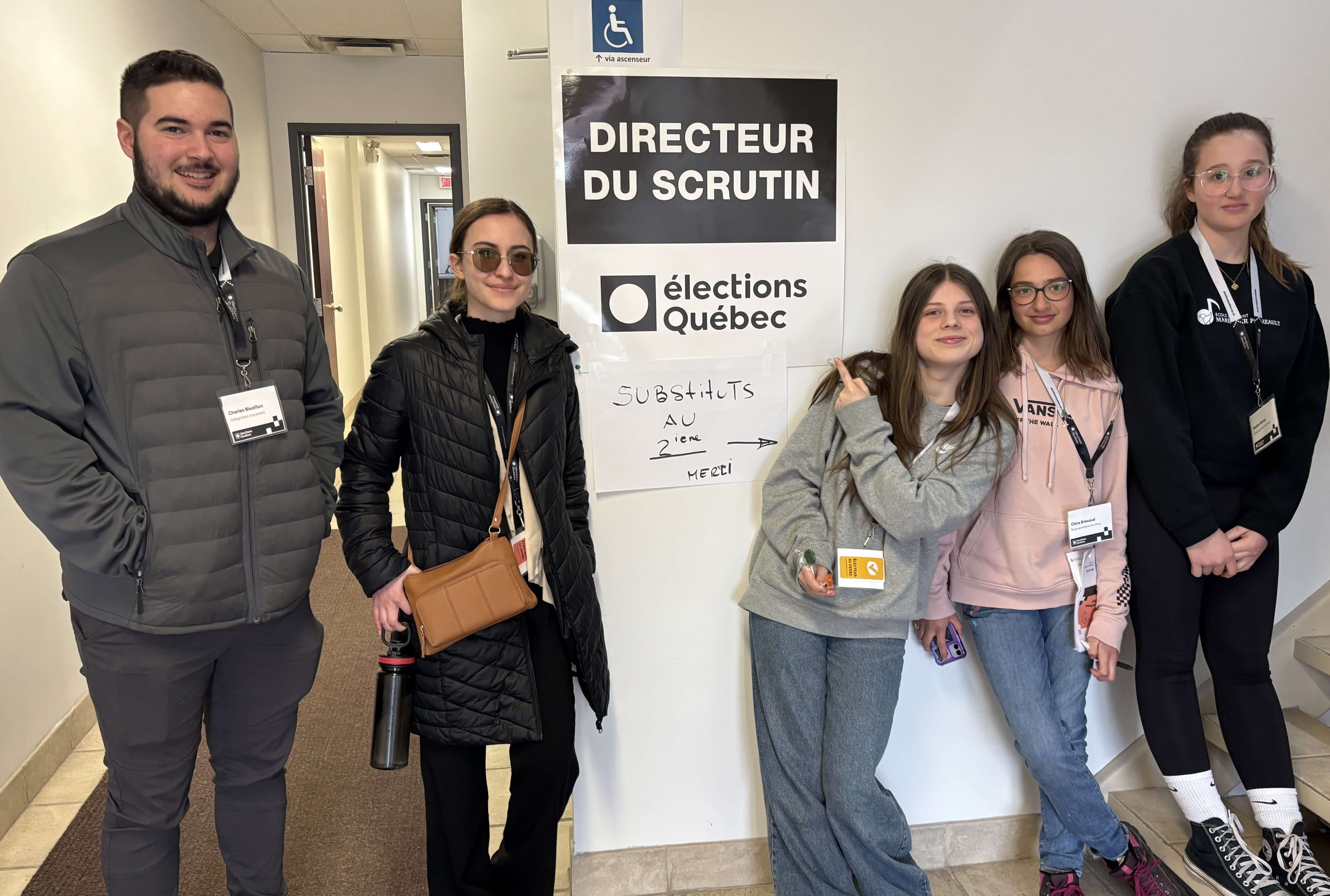 Cinq jeunes devant le bureau du directeur du scrutin.