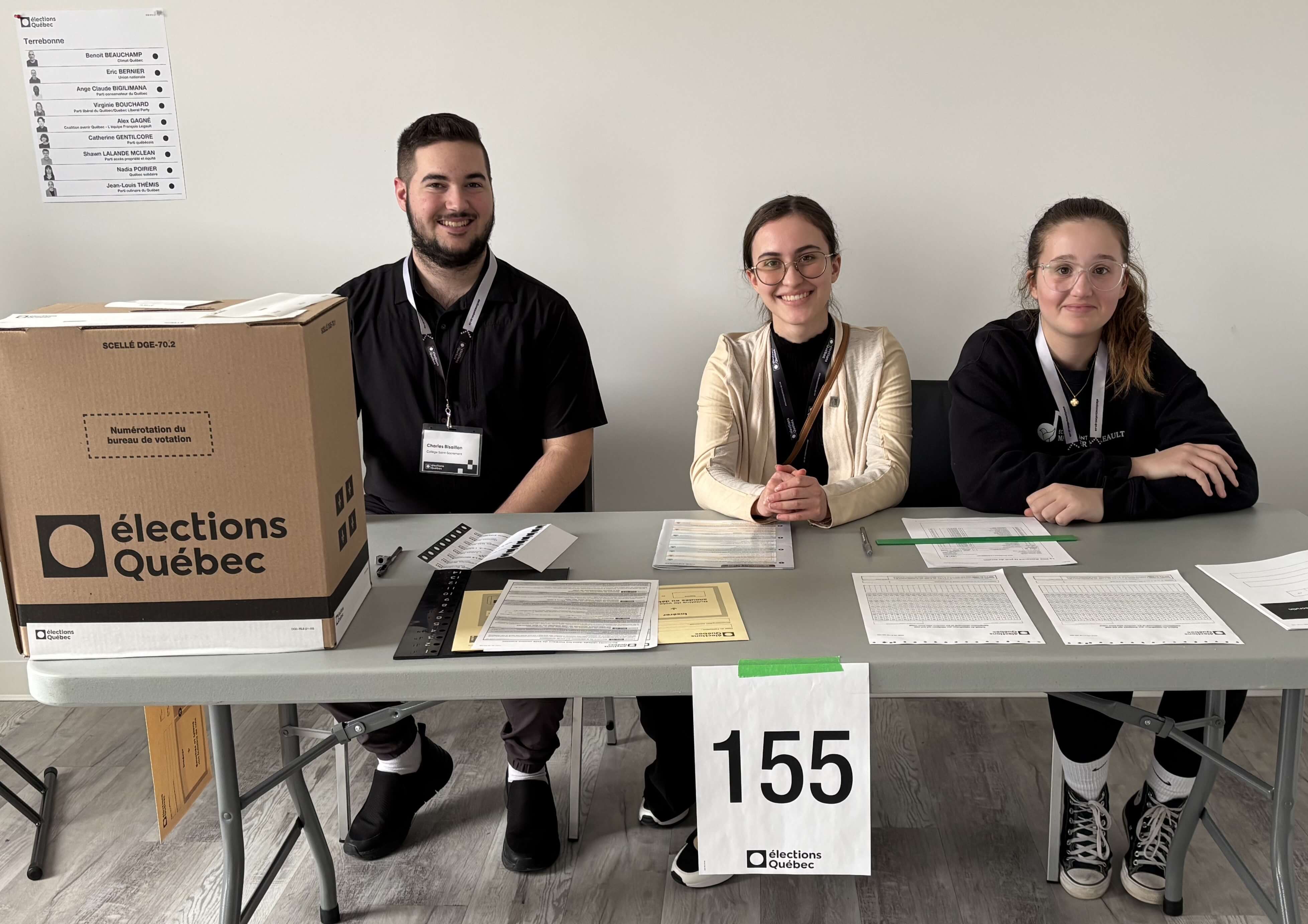 Trois jeunes assis à une table de vote.